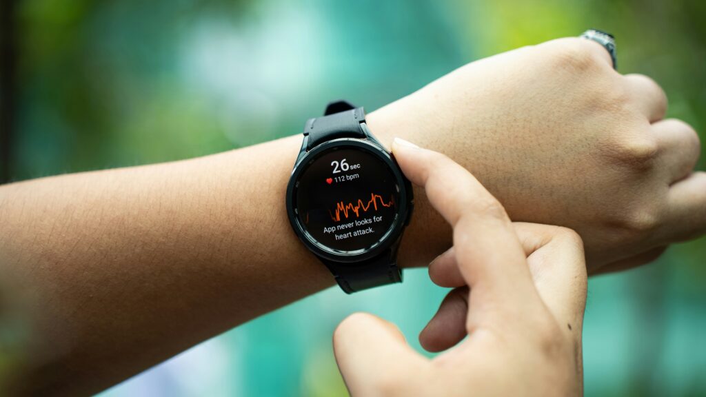 Smartwatch am Handgelenk zeigt Herzfrequenzmessung mit Puls-Diagramm